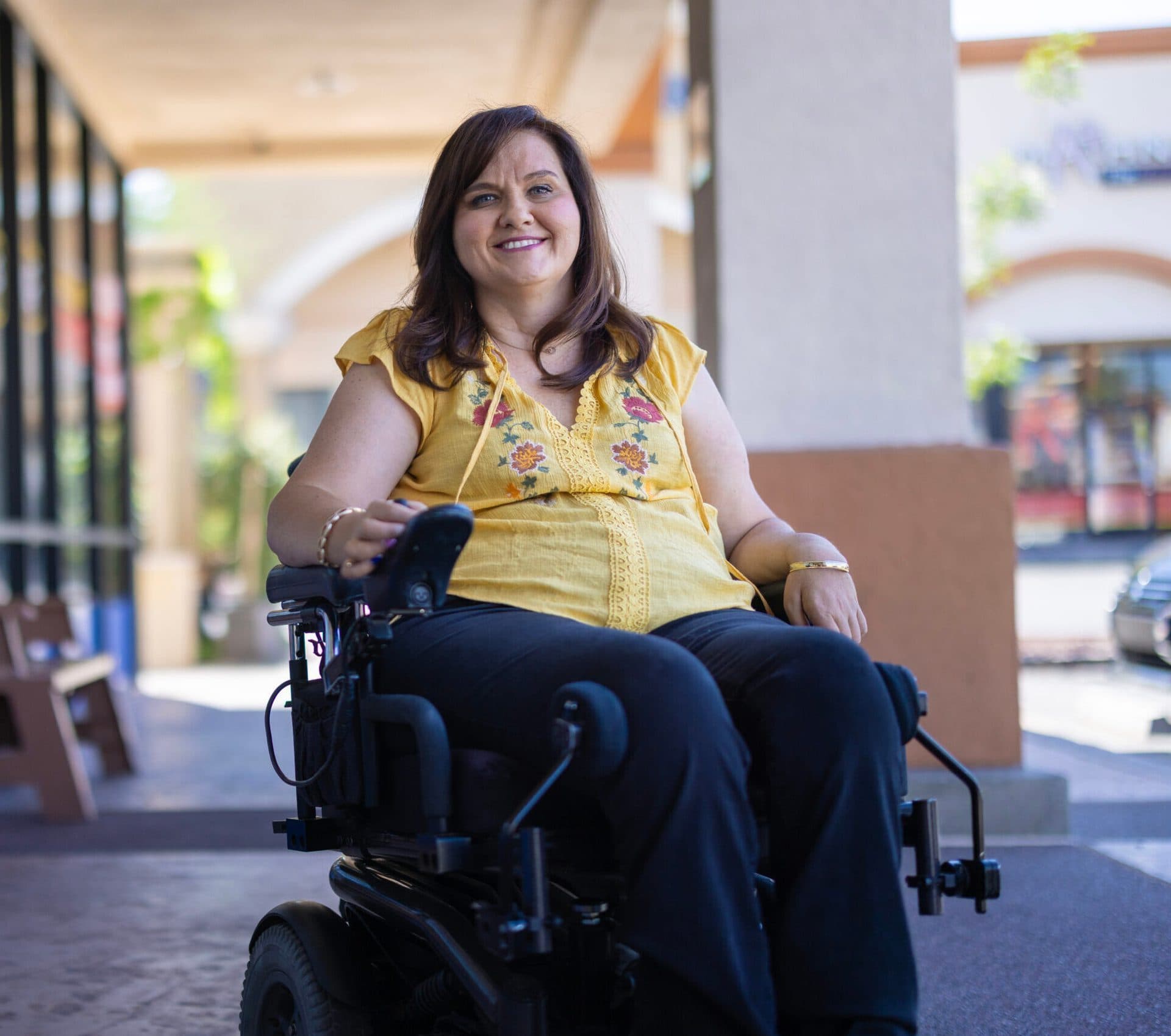 Adult woman in a power wheelchair outdoors